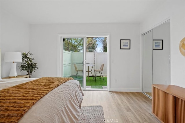 bedroom with access to exterior and light hardwood / wood-style flooring