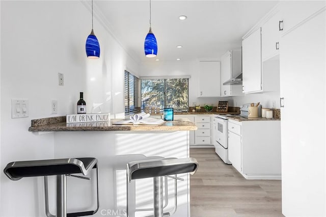 kitchen featuring pendant lighting, white cabinets, kitchen peninsula, and white range