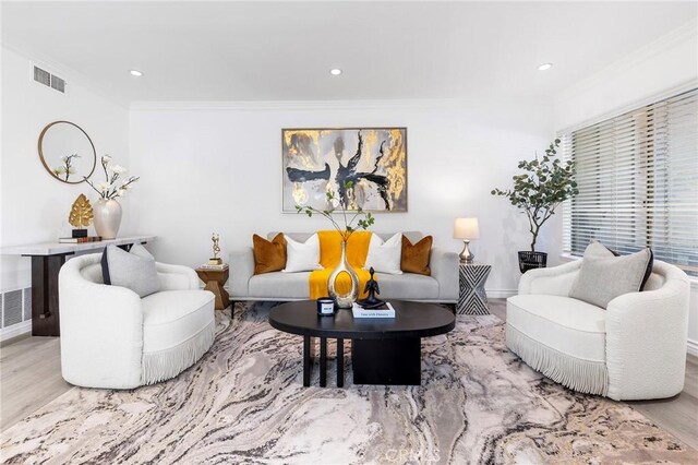 living room featuring light wood-type flooring and ornamental molding