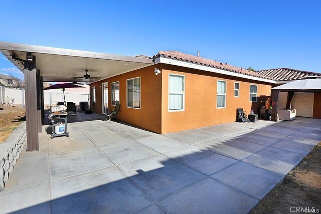 view of side of home with ceiling fan, a gazebo, and a patio area