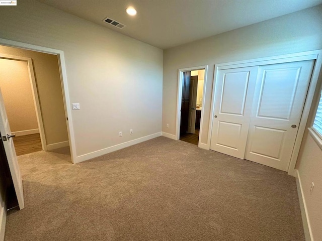 unfurnished bedroom with a closet and carpet flooring