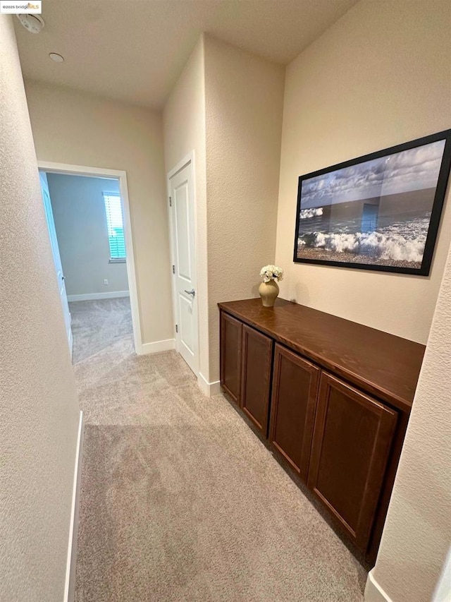 hall featuring light colored carpet