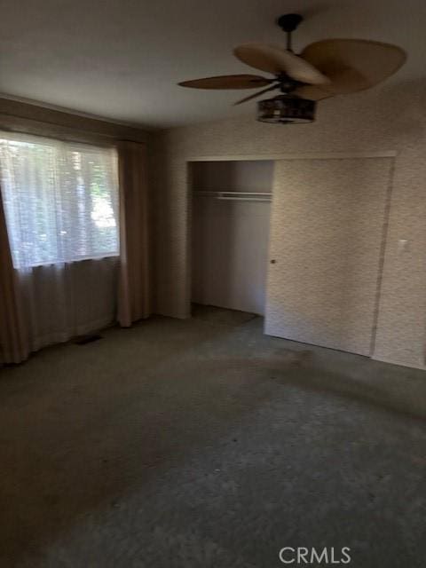 unfurnished bedroom featuring ceiling fan, a closet, and lofted ceiling