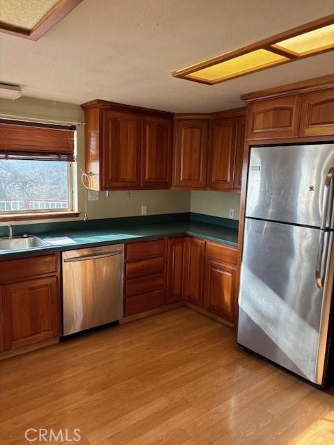 kitchen featuring sink, appliances with stainless steel finishes, and light wood-type flooring