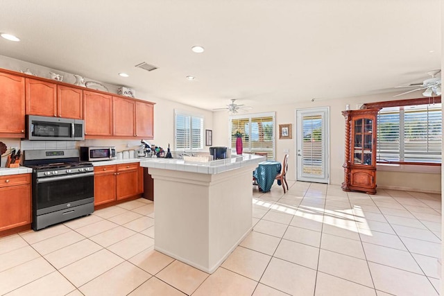 kitchen with ceiling fan, light tile patterned flooring, and stainless steel appliances