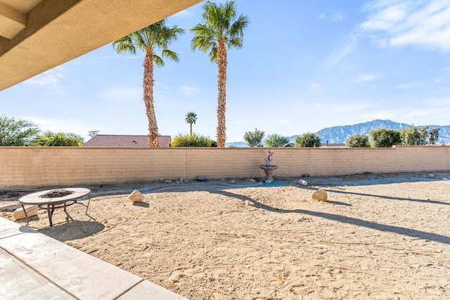 view of yard with a mountain view and an outdoor fire pit