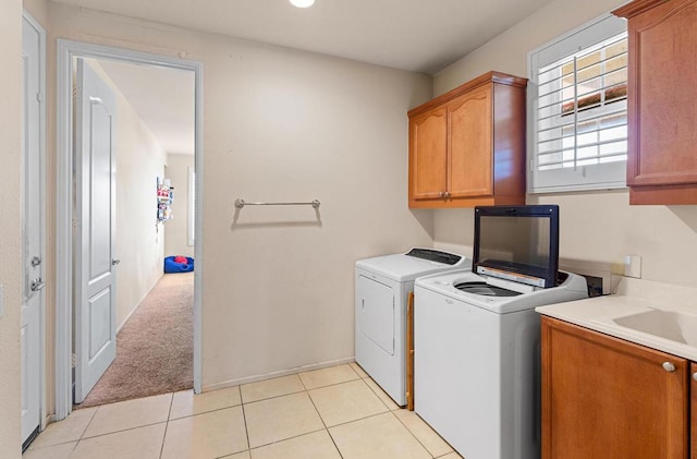 washroom with sink, cabinets, washer and clothes dryer, and light carpet