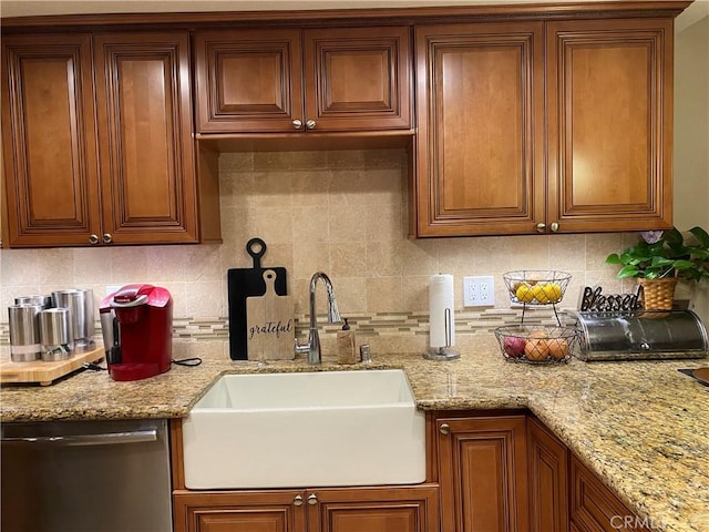 kitchen with decorative backsplash, light stone counters, dishwasher, and sink