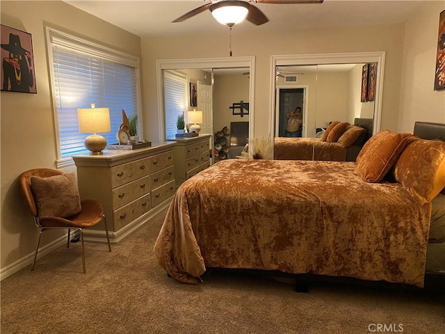 bedroom featuring carpet flooring, ceiling fan, and multiple closets