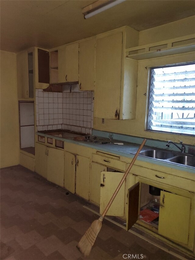 kitchen featuring cream cabinetry, sink, and decorative backsplash