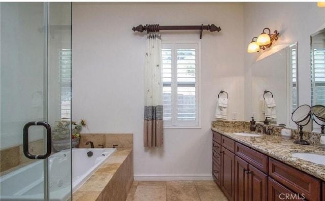 bathroom featuring tiled bath, vanity, and tile patterned flooring