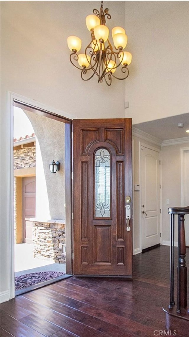 entrance foyer with a high ceiling, dark hardwood / wood-style floors, and a chandelier