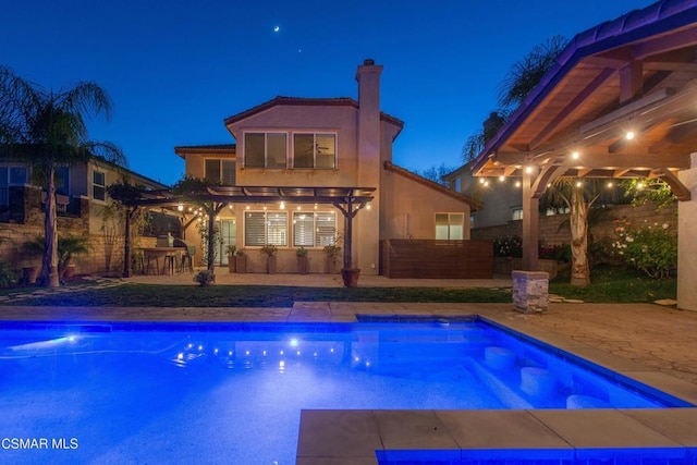 pool at twilight featuring a bar and a patio