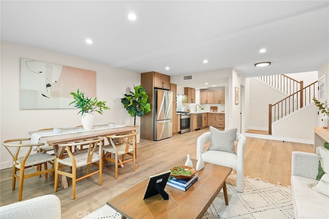 living room with light hardwood / wood-style flooring and sink