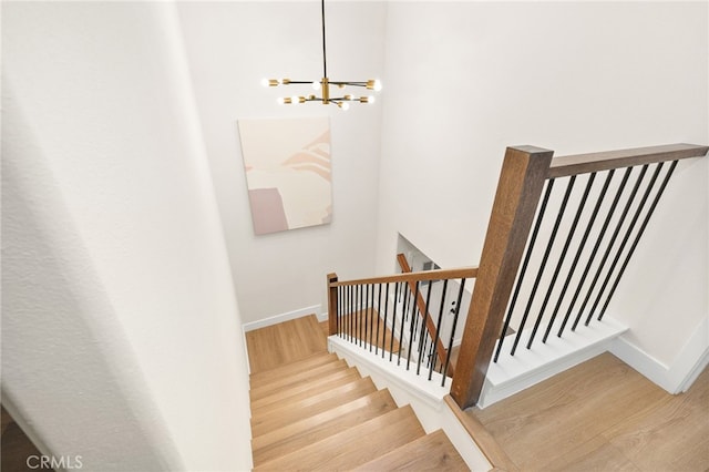 stairs featuring an inviting chandelier and hardwood / wood-style floors