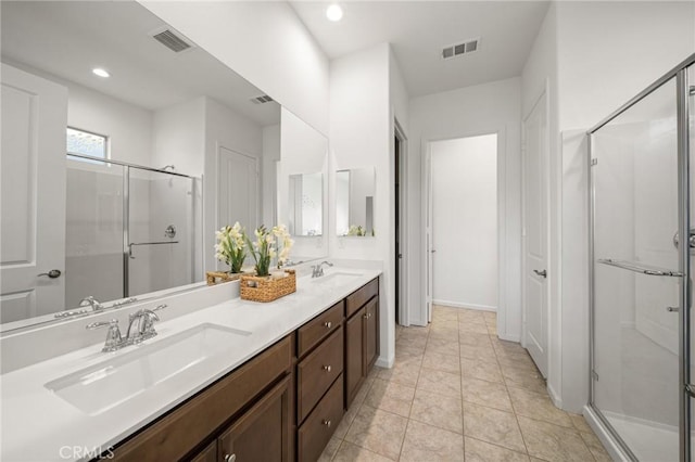 bathroom with a shower with shower door, vanity, and tile patterned flooring