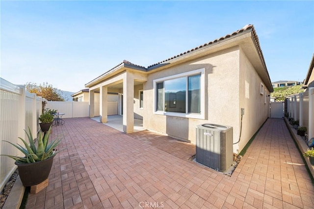 rear view of house with cooling unit and a patio