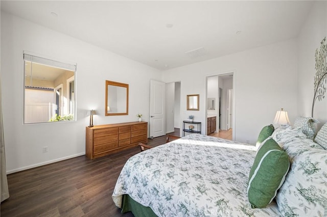 bedroom with ensuite bathroom and dark hardwood / wood-style floors