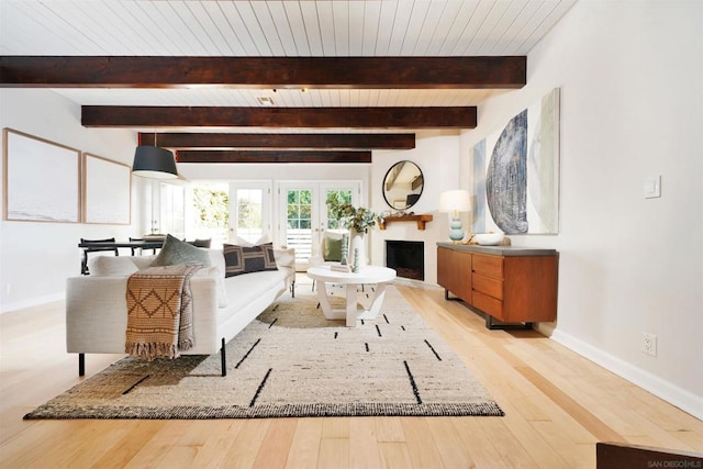 living room with beam ceiling, light wood-type flooring, french doors, and wooden ceiling