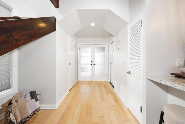 hall with light hardwood / wood-style floors and french doors