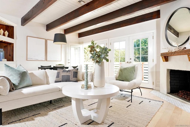 living room with light wood-type flooring, french doors, and beamed ceiling