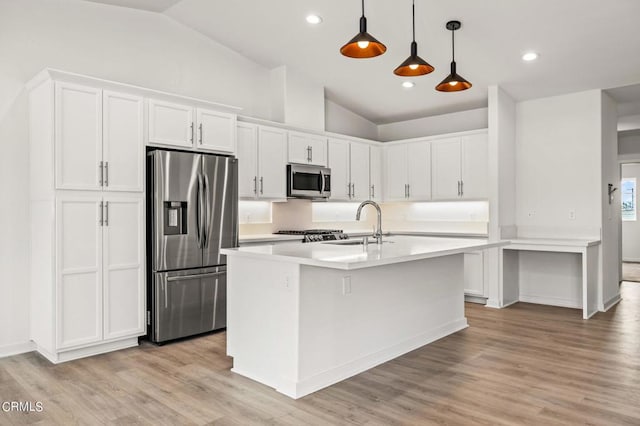 kitchen with white cabinetry, hanging light fixtures, appliances with stainless steel finishes, and lofted ceiling