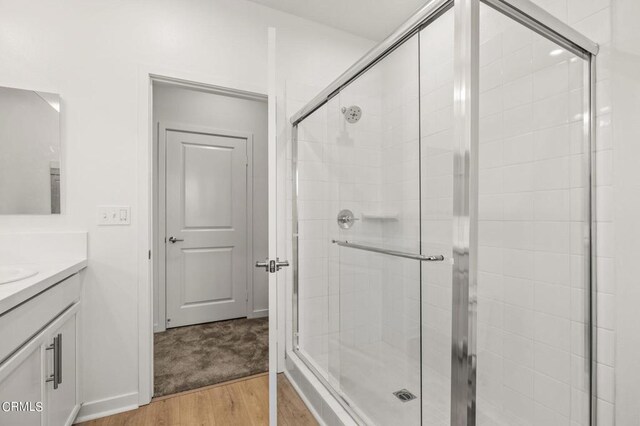 bathroom featuring vanity, a shower with door, and hardwood / wood-style flooring