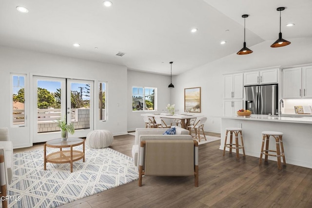 living room with dark hardwood / wood-style flooring, lofted ceiling, and sink