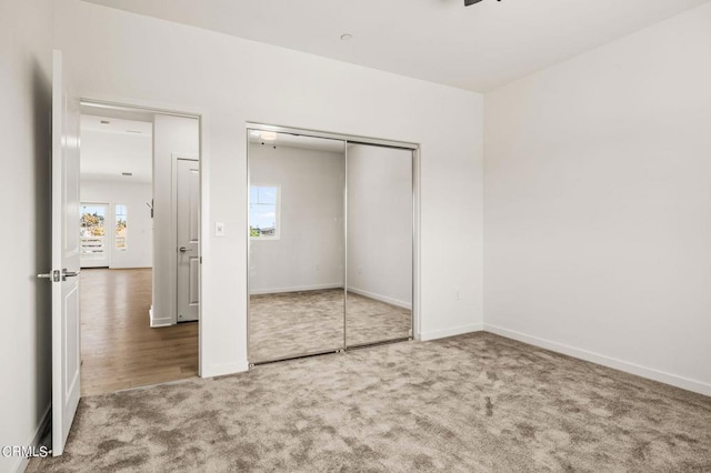 unfurnished bedroom with a closet and carpet flooring