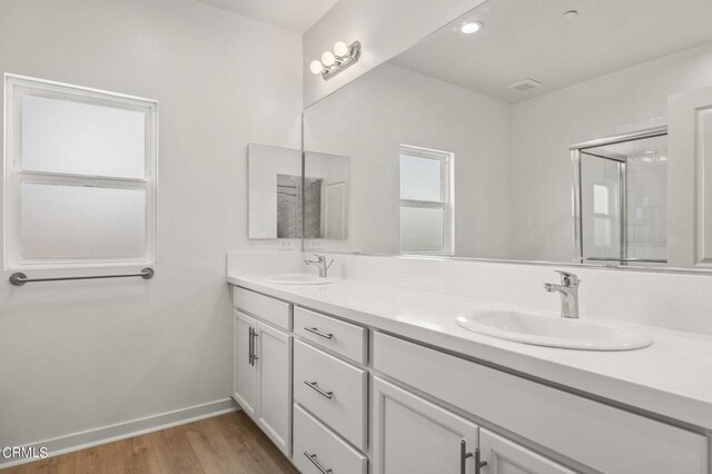 bathroom featuring a shower with shower door, wood-type flooring, and vanity