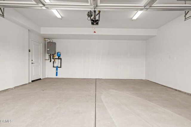 garage featuring water heater and a garage door opener