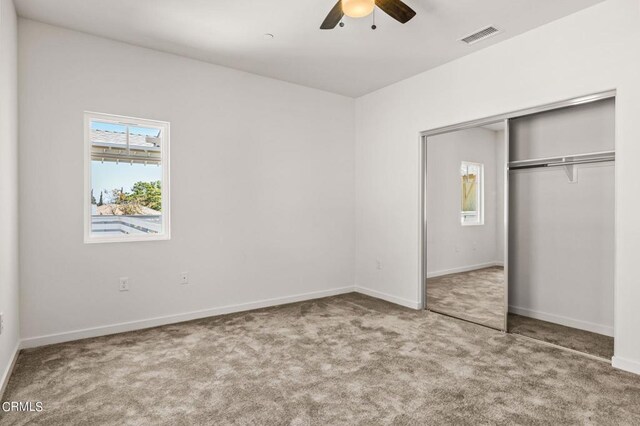 unfurnished bedroom with ceiling fan, carpet, and a closet