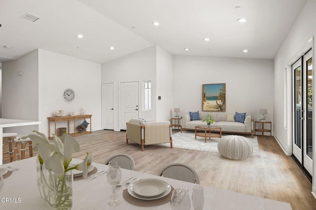 living room featuring vaulted ceiling and light hardwood / wood-style floors