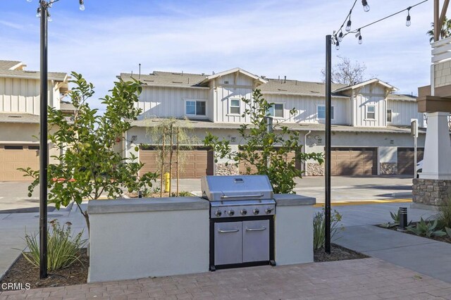 view of patio featuring grilling area, a garage, and an outdoor kitchen