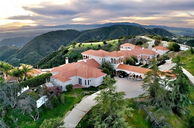 aerial view at dusk featuring a mountain view