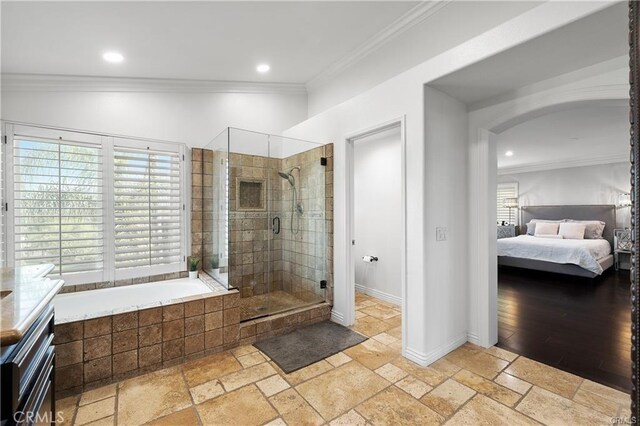 bathroom featuring a wealth of natural light, ornamental molding, and independent shower and bath