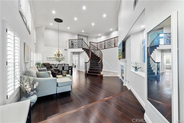 living room with a healthy amount of sunlight, dark hardwood / wood-style floors, and a high ceiling