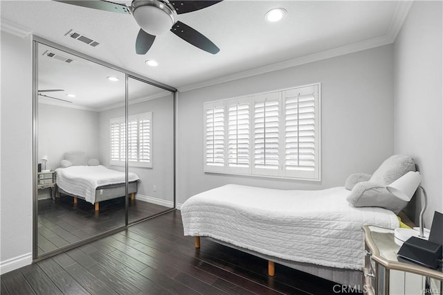 bedroom featuring a closet, crown molding, hardwood / wood-style flooring, and ceiling fan