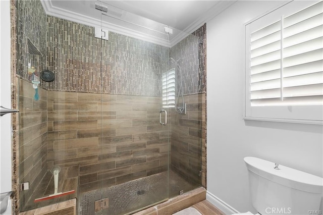 bathroom featuring an enclosed shower, toilet, and crown molding