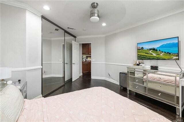 bedroom featuring ceiling fan, dark wood-type flooring, a closet, and ornamental molding