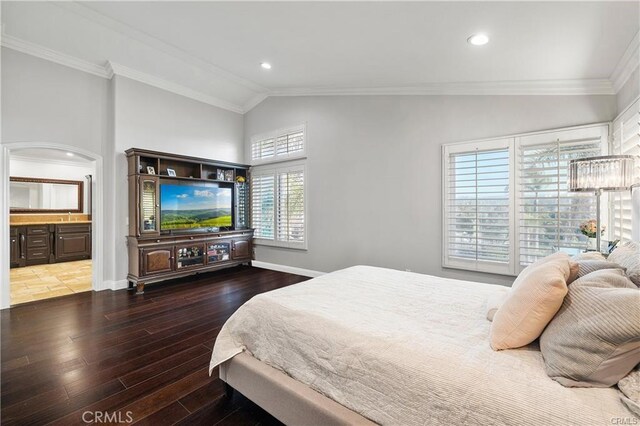 bedroom featuring ornamental molding, lofted ceiling, multiple windows, and ensuite bath