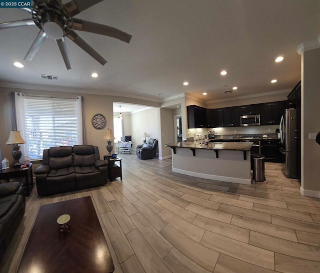 living room featuring ceiling fan, crown molding, and light hardwood / wood-style flooring