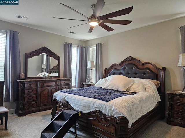 carpeted bedroom with ceiling fan and multiple windows