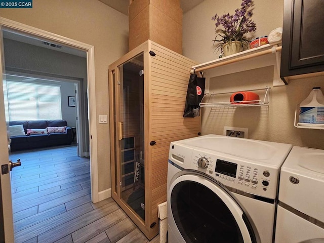 washroom with cabinets, washer and clothes dryer, light hardwood / wood-style flooring, and sink