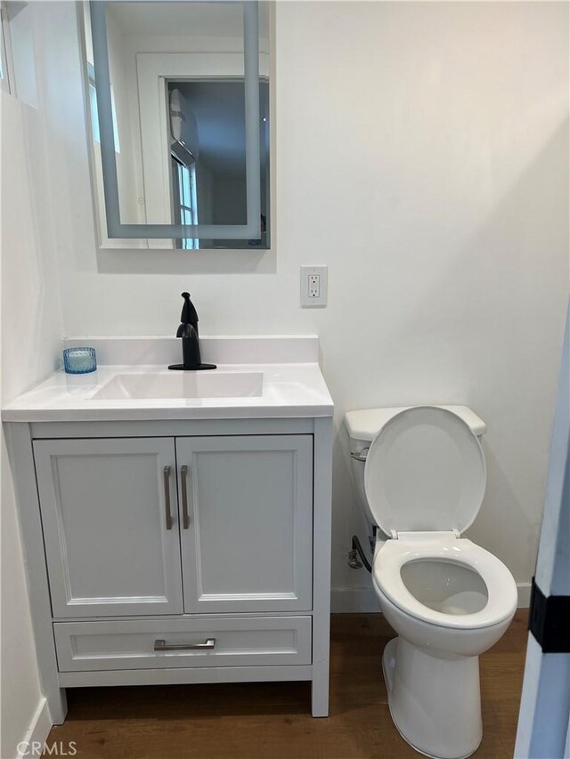 bathroom featuring hardwood / wood-style flooring, vanity, and toilet