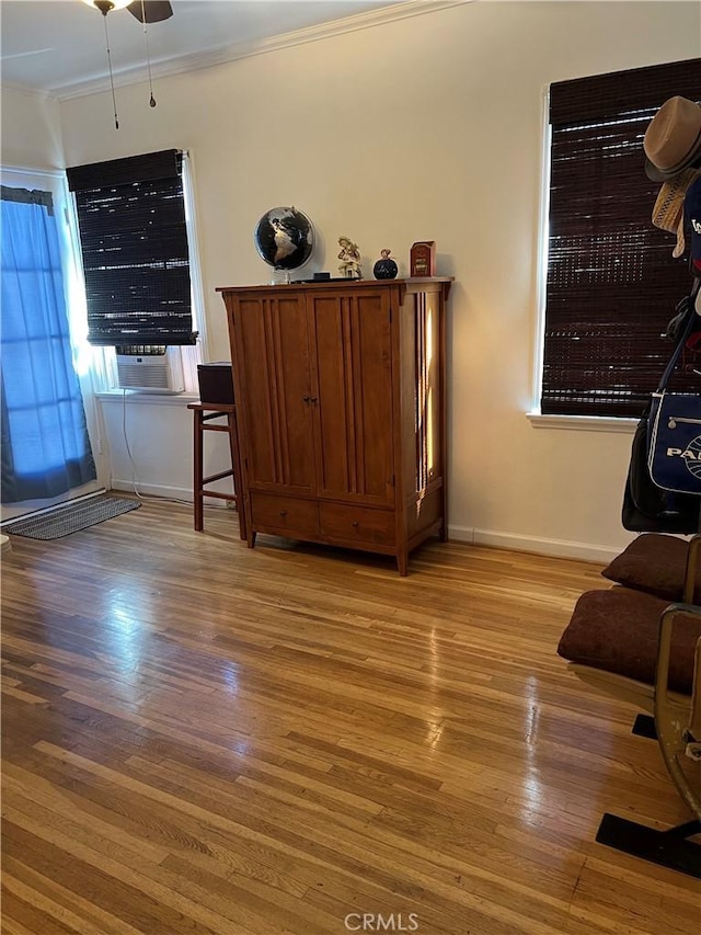 living room featuring crown molding and light hardwood / wood-style flooring