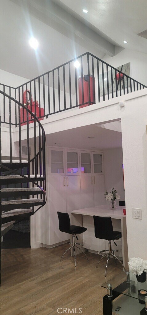 stairway featuring a towering ceiling and hardwood / wood-style flooring