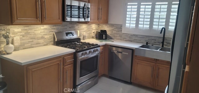 kitchen featuring sink, light tile patterned floors, stainless steel appliances, and tasteful backsplash