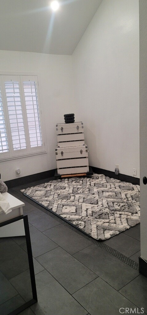 bedroom featuring lofted ceiling and tile patterned flooring