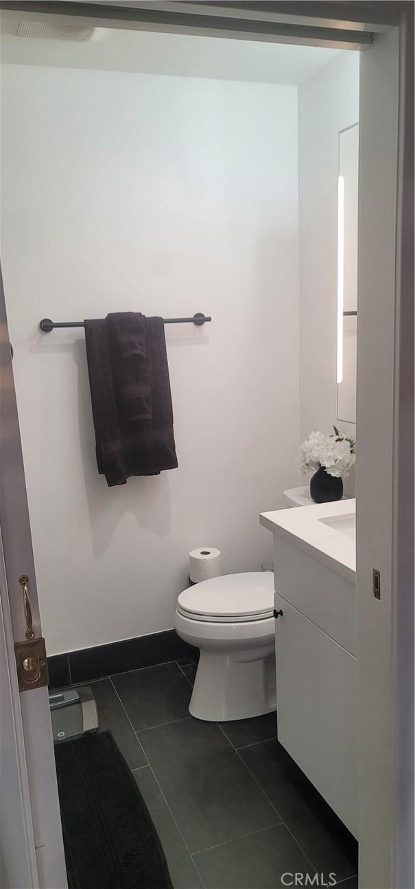 bathroom featuring toilet, tile patterned flooring, and vanity